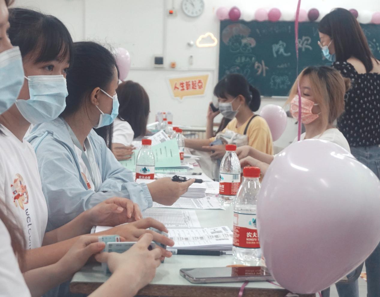 图为迎新学长帮助新生办理报到手续 图为迎新学长帮助新生办理报到手续
