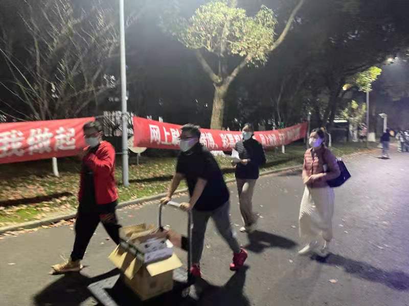 (图为志愿者搬送慰问品与老师看望学生) (图为志愿者搬送慰问品与老师看望学生)