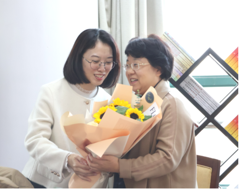图为余绘平向教职工代表鲜花 图为余绘平向教职工代表鲜花